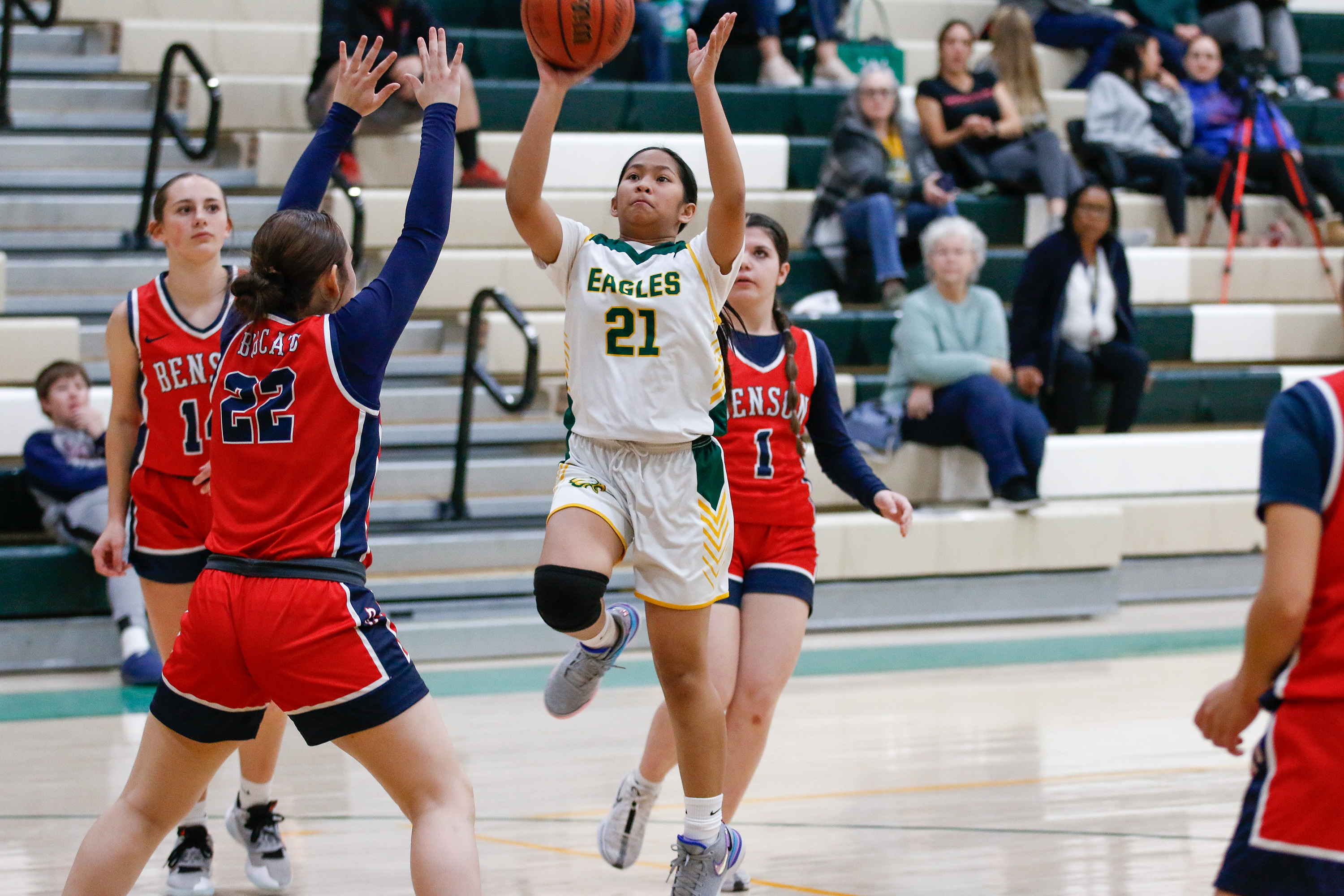 A Santa Rita player jumps up to throw the ball into the basket over her opponents' heads