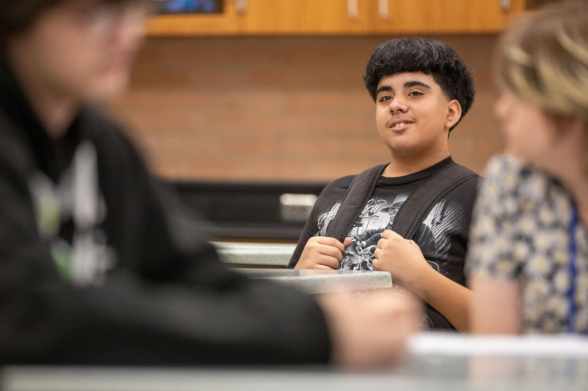 A student smiles in his classroom on the first day of school