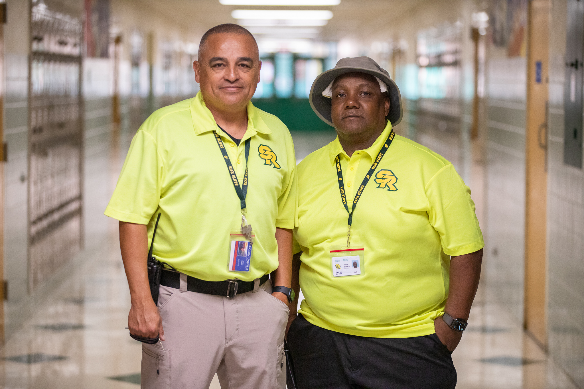 Two school safety officers smile in the hallway on the first day