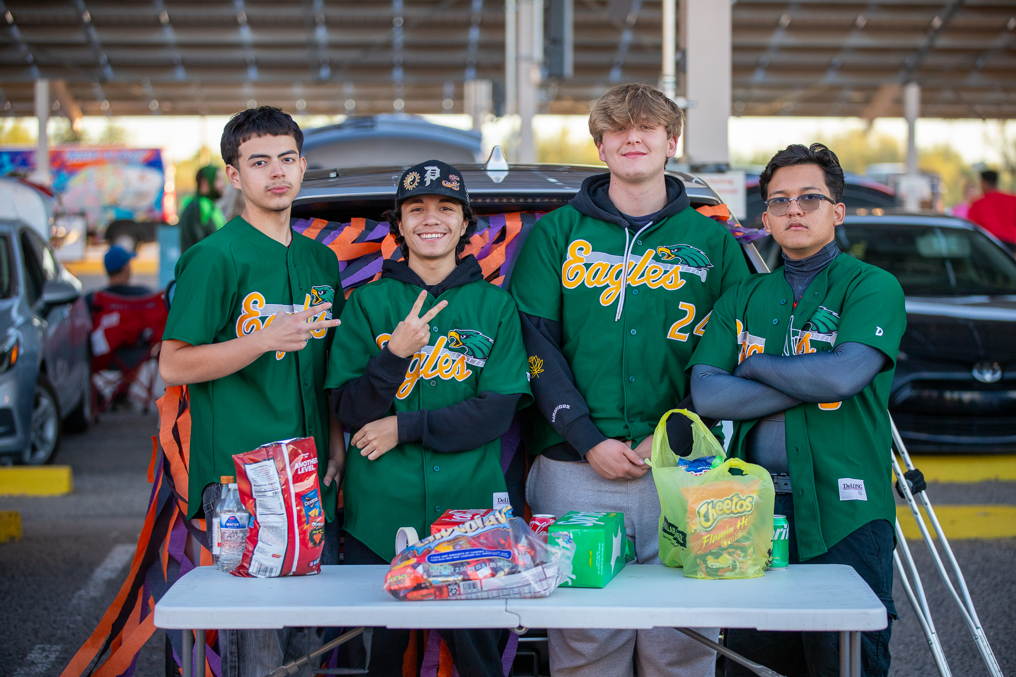 Four students in their Eagles jerseys pose at their table