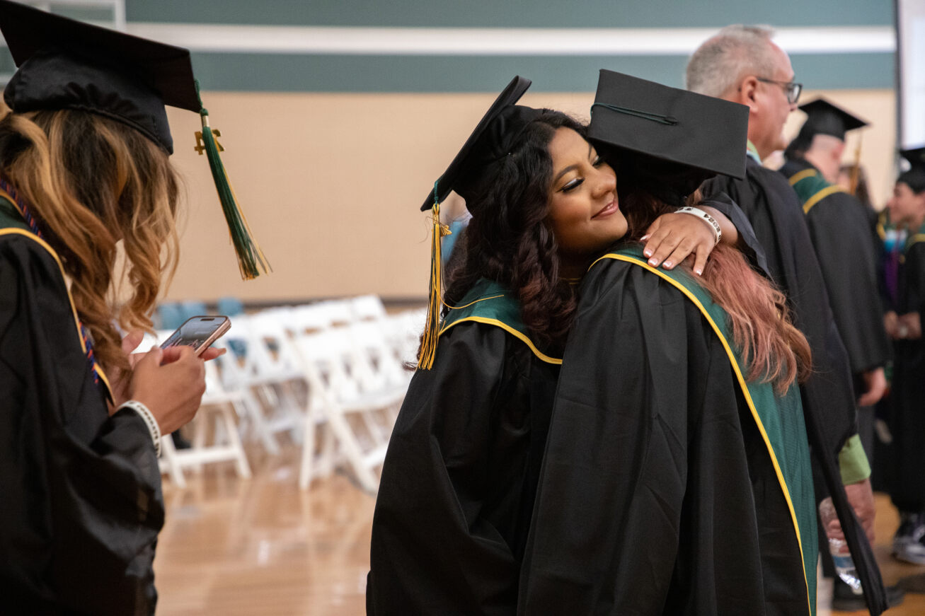 Two Santa Rita grads hug each other in the gym